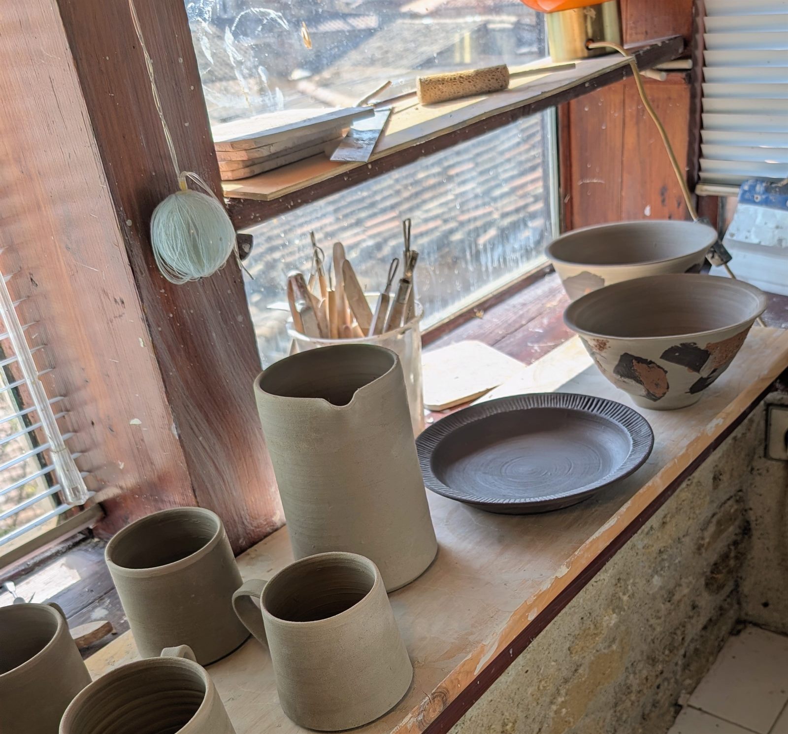Pièces en grès en cours de séchage dans l'atelier